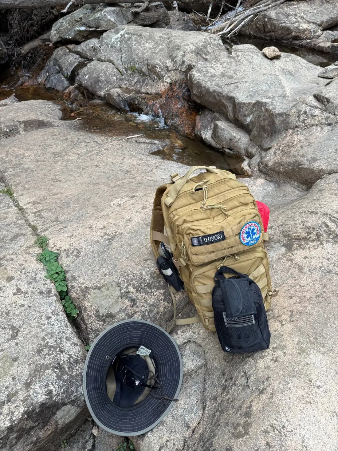 Hiking gear beside a mountain stream